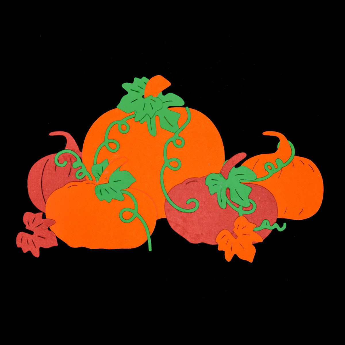 Colourful autumn pumpkin, leaf and vine paper die cuts displayed against a black background for papercraft inspiration.