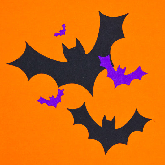Finished bat shapes cut from card using metal cutting dies on orange background