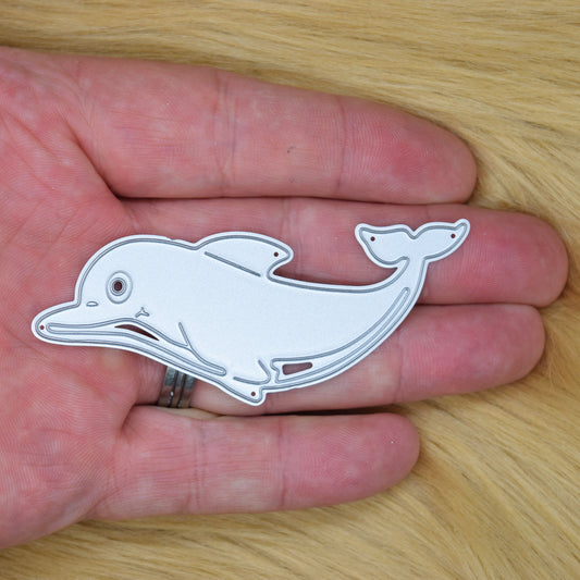 Dolphin metal cutting die held in hand showing size and sea life design for card making