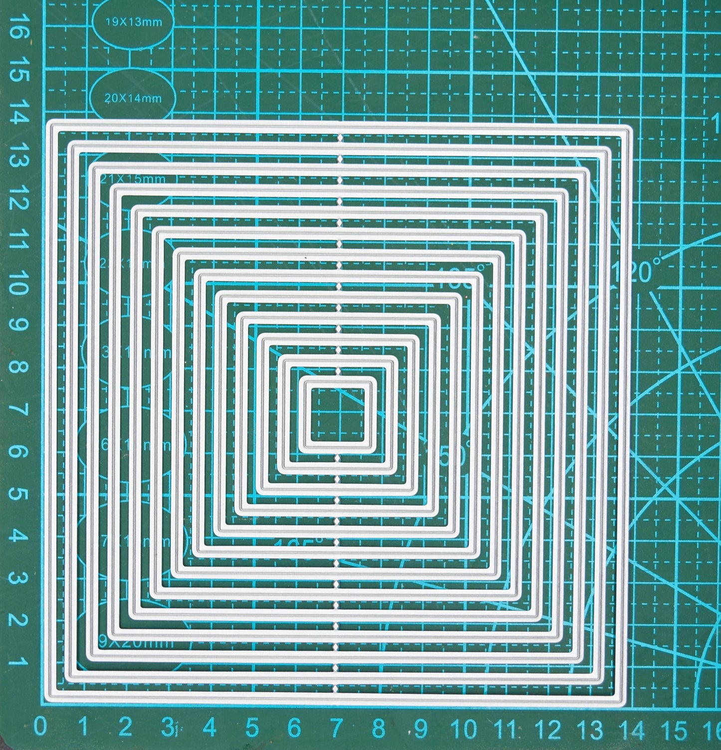 Large square nesting metal cutting dies set on measuring mat showing graduated sizes