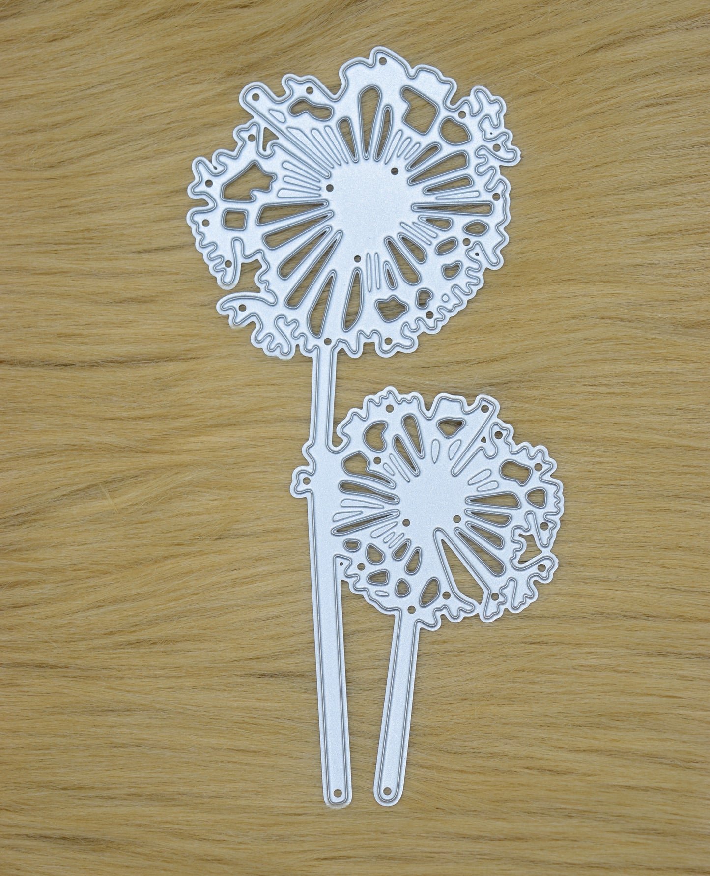 Dandelion metal cutting die displayed on wooden surface for papercraft projects