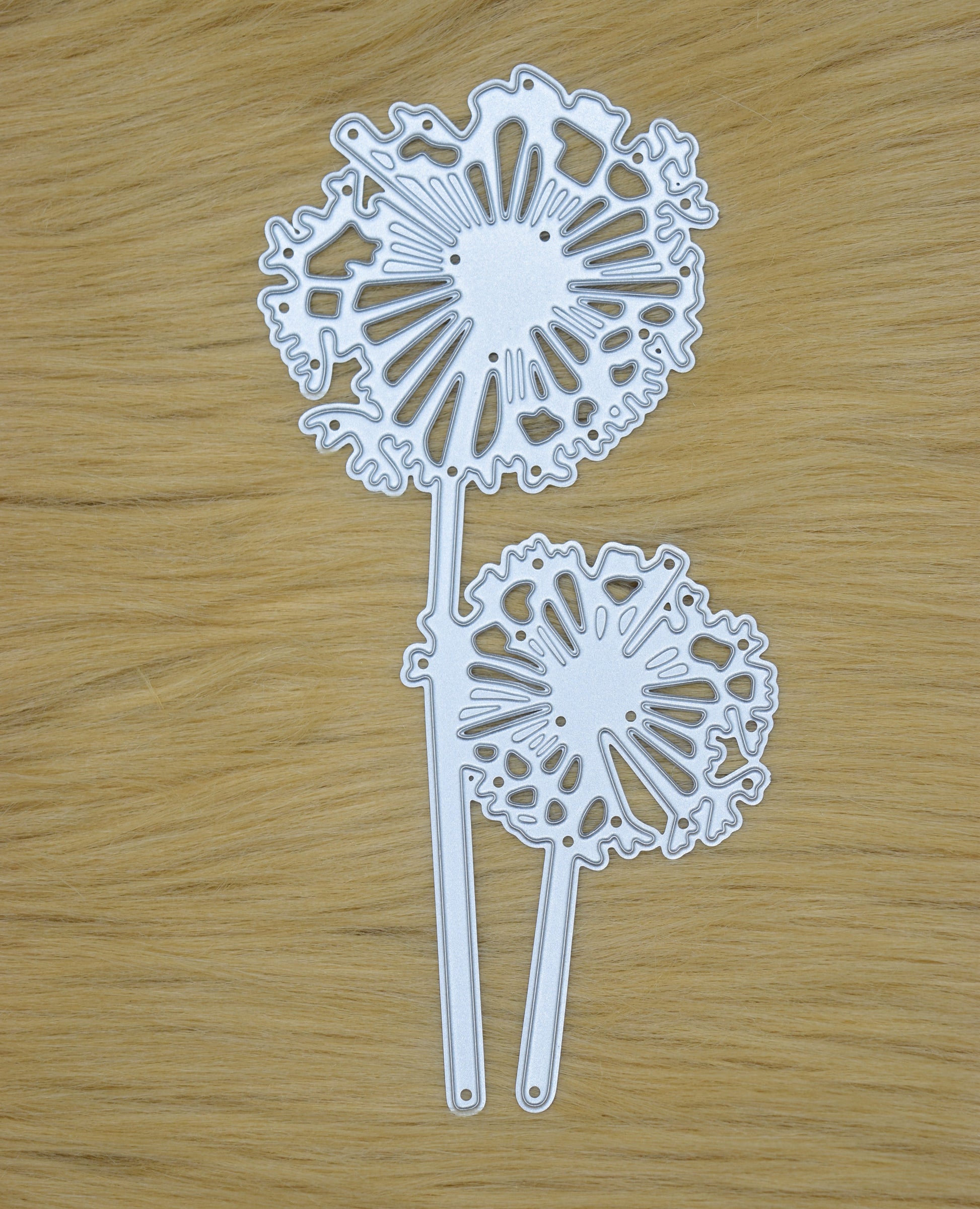 Dandelion metal cutting die displayed on wooden surface for papercraft projects