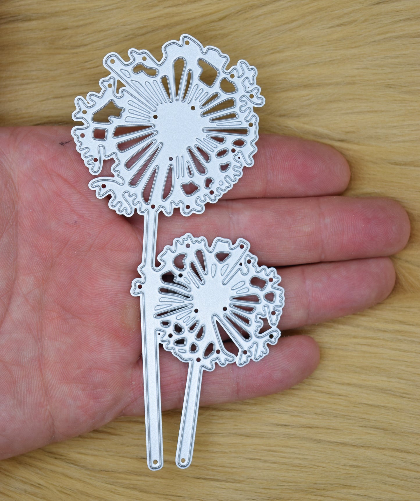 Dandelion flower metal cutting die held in hand to show size for card making