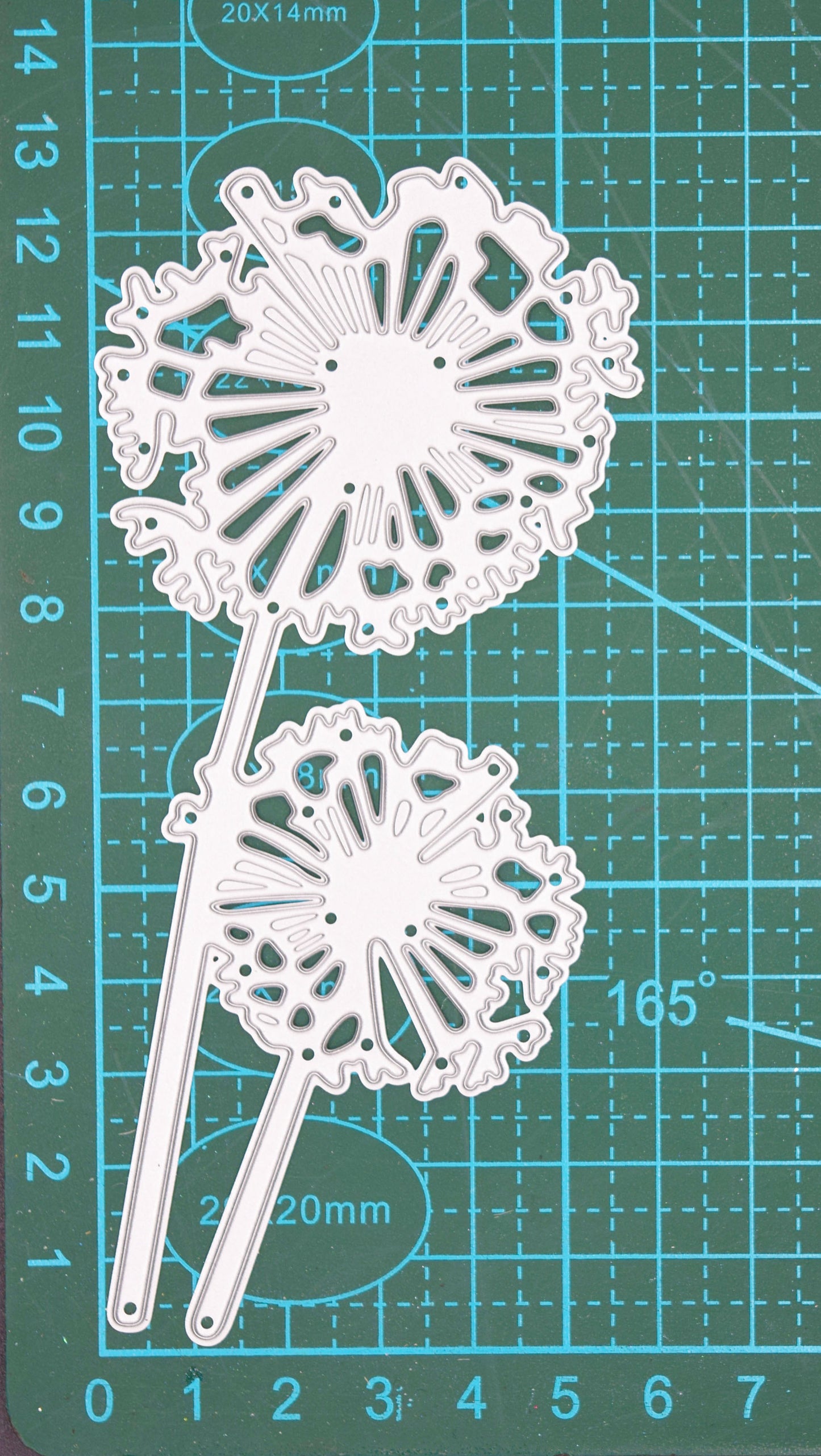Dandelion flower metal cutting die on grid cutting mat showing size and detail
