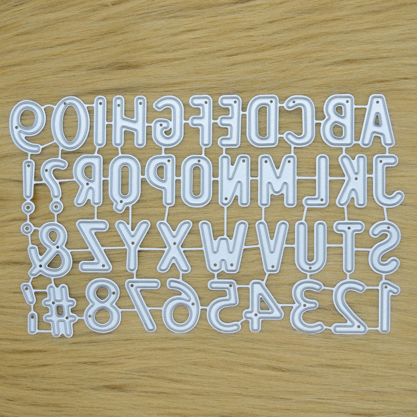 Uppercase alphabet and number dies set on wood background