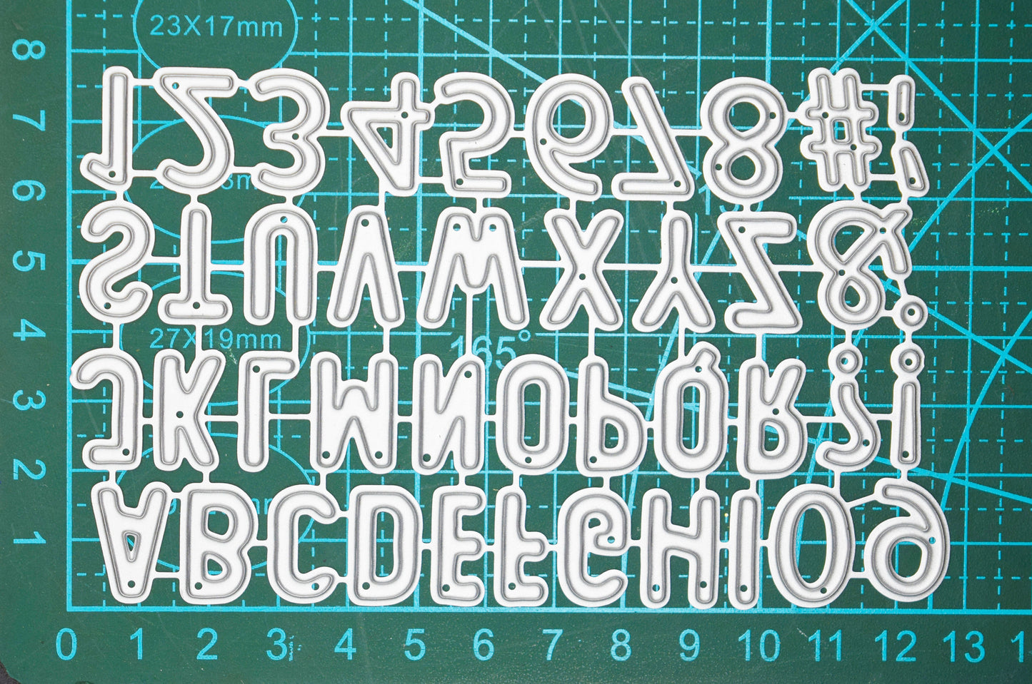Alphabet cutting dies on cutting mat showing size reference