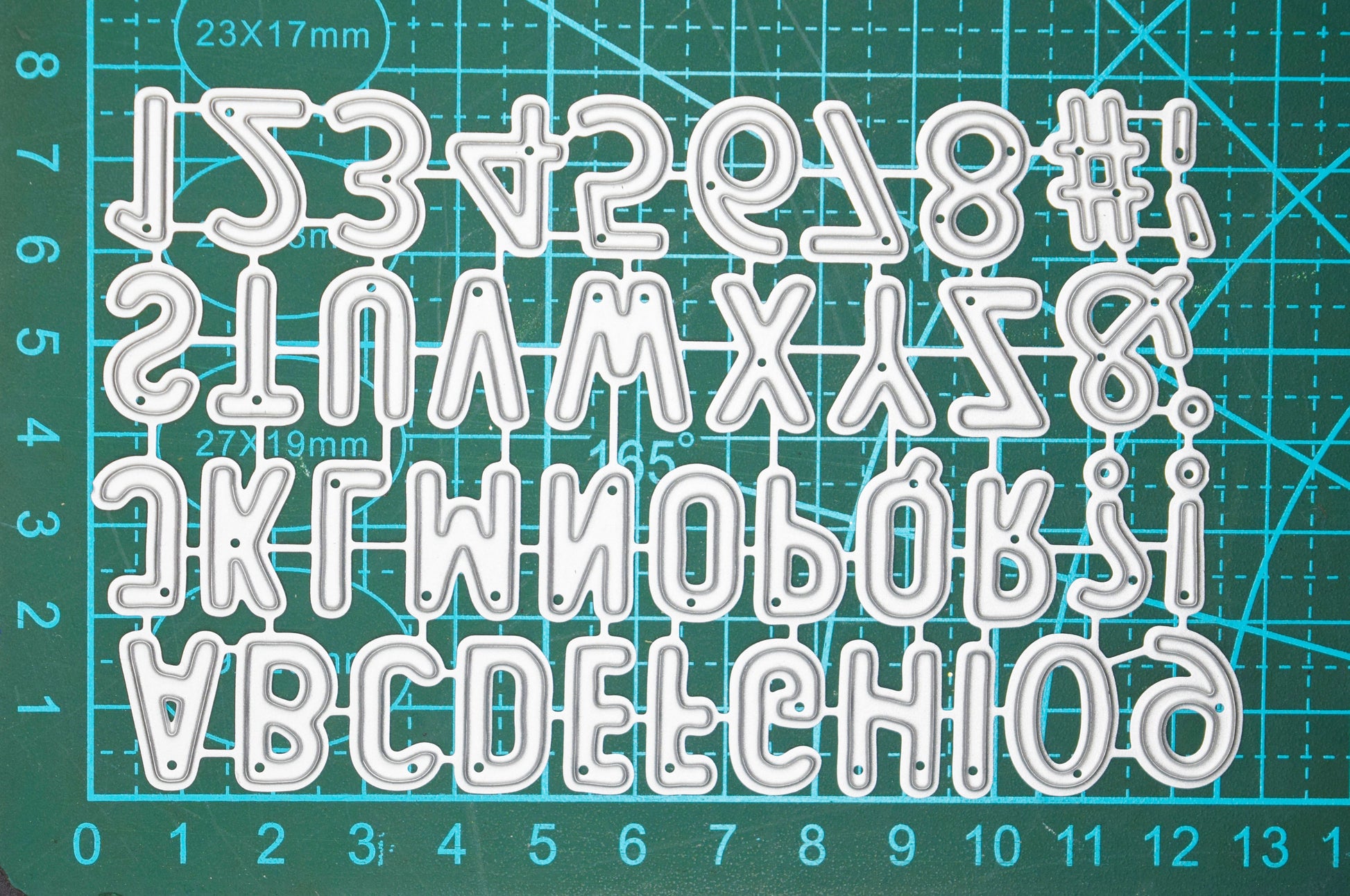 Alphabet cutting dies on cutting mat showing size reference