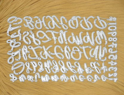 Uppercase & lowercase alphabet and numbers metal cutting dies set displayed on a faux fur background for card making, scrapbooking and DIY papercrafts.