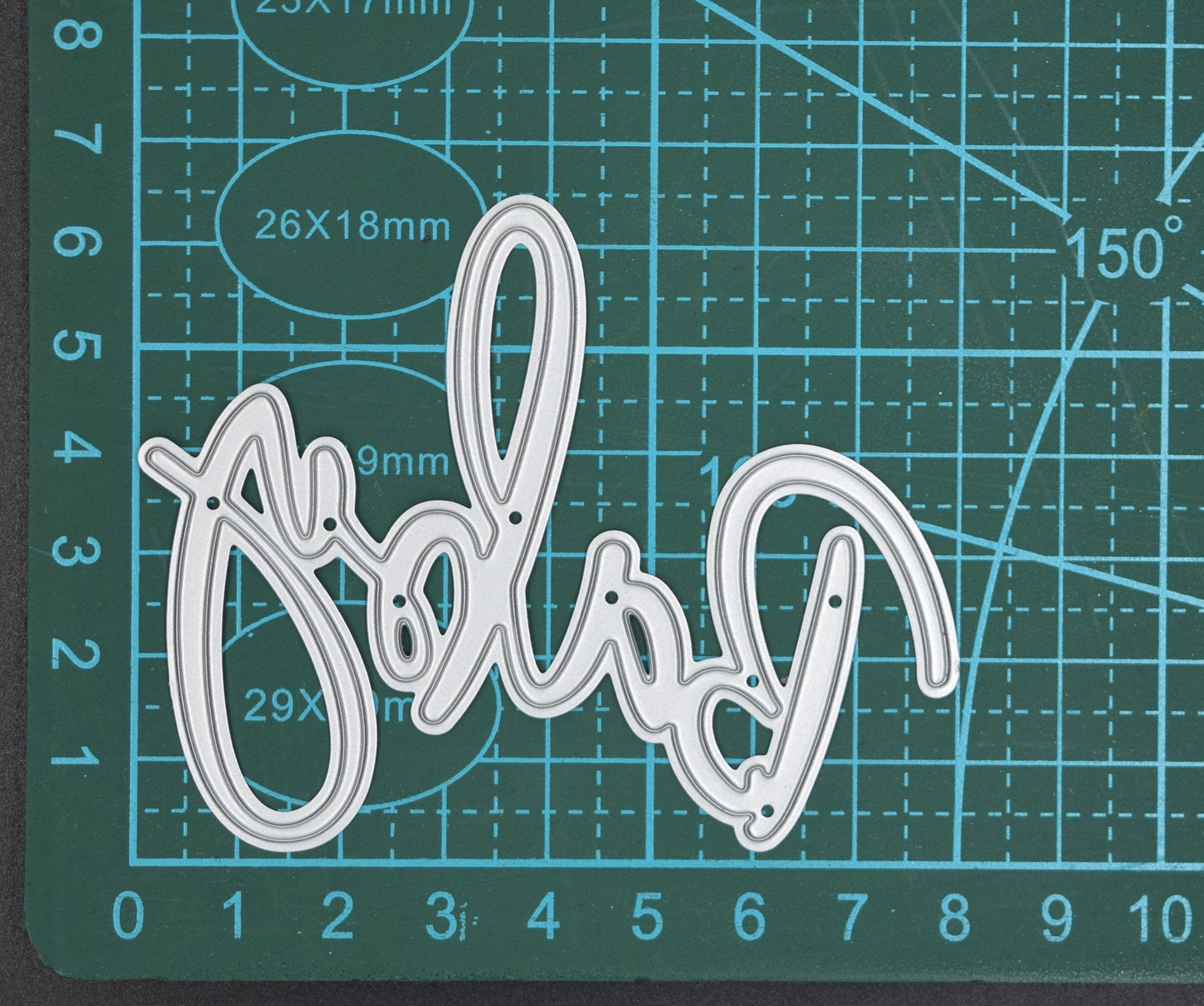 Baby script sentiment metal cutting die shown on measuring mat for sizing