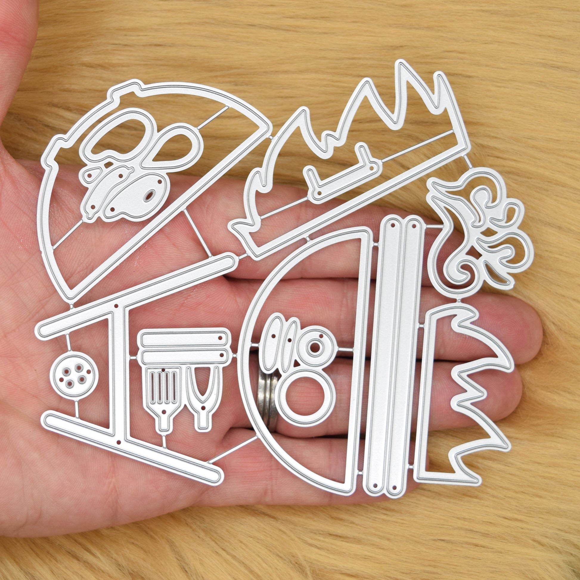 Large BBQ barbecue grill metal cutting die set shown in hand for size reference and scale for papercraft and card making