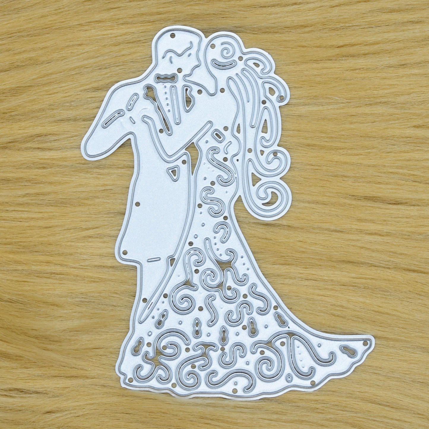 Bride and groom metal cutting die shown on faux fur background