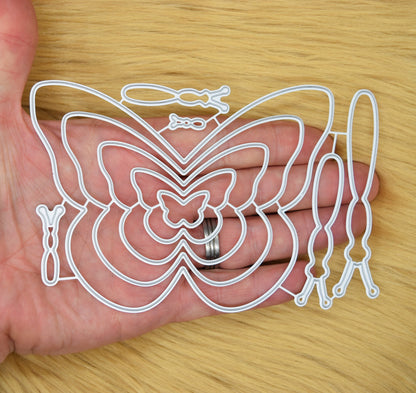 Butterfly cutting dies held in hand for size reference