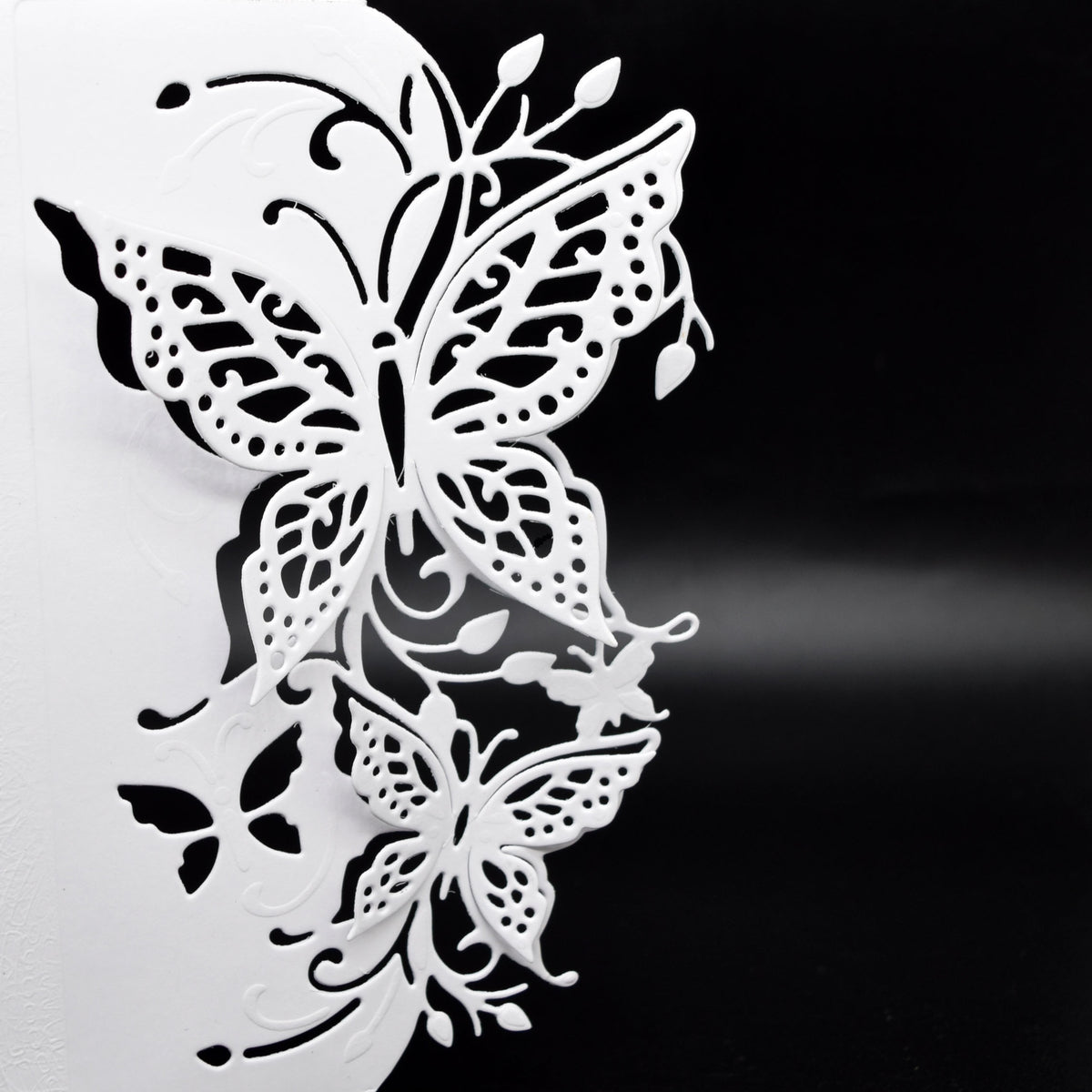 Close-up of the finished 3D butterfly edge with intricate wing cut-outs, foliage and decorative flourishes on white card.
