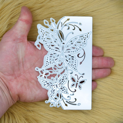 Butterfly edge metal cutting die held vertically in hand to show the overall size and intricate butterfly border design.