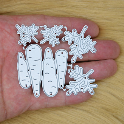 Carrot metal cutting dies shown in hand for size reference including layered carrot shapes and leafy tops for papercraft projects