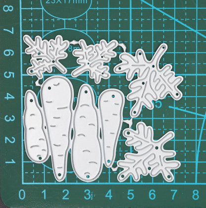Carrot metal cutting dies set on cutting mat showing multiple carrot and leafy top designs for gardening and vegetable themed card making