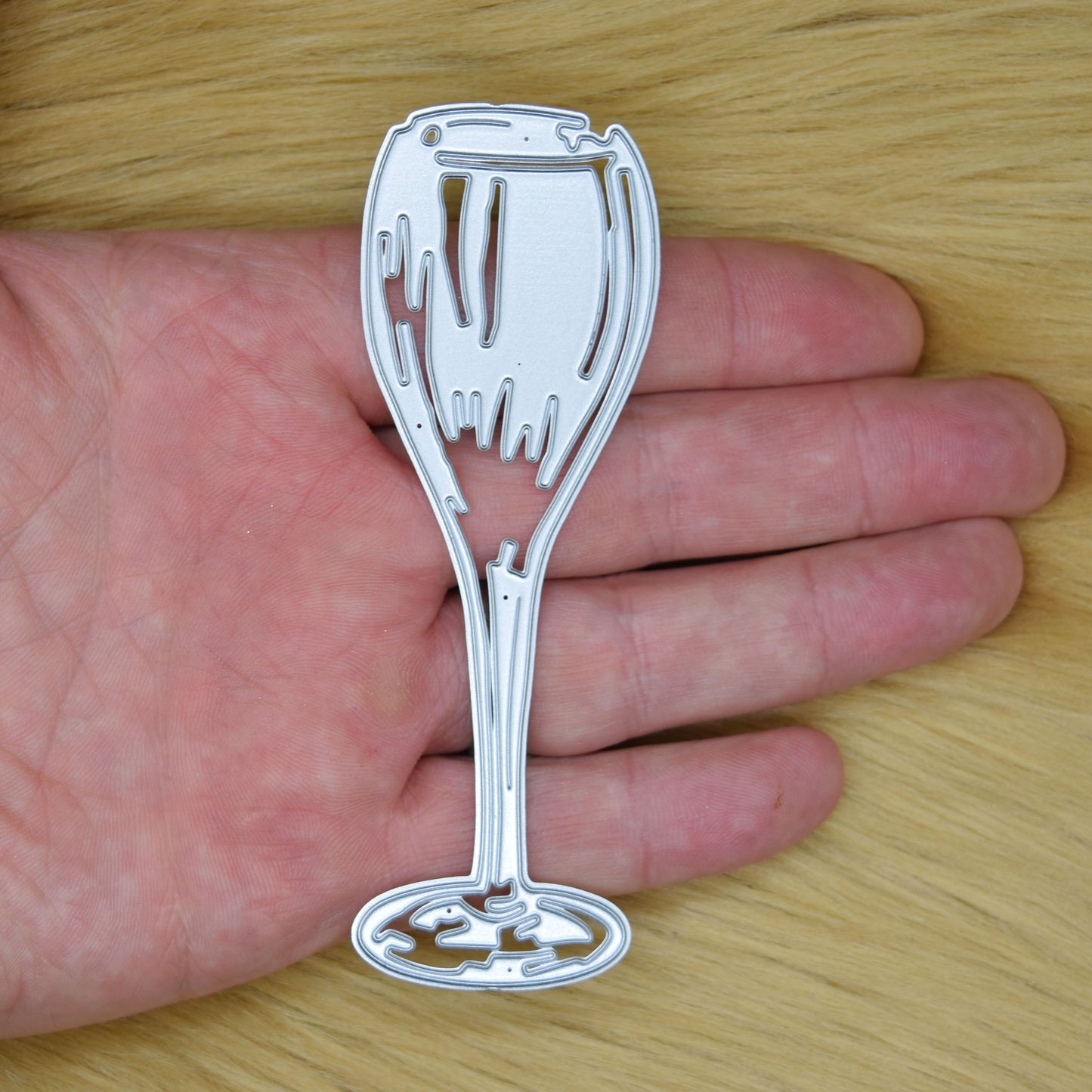 Champagne glass metal cutting die size comparison shown in hand