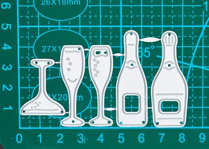 Champagne bottle and glass metal cutting dies on a centimetre cutting mat, showing the overall set size for card making.