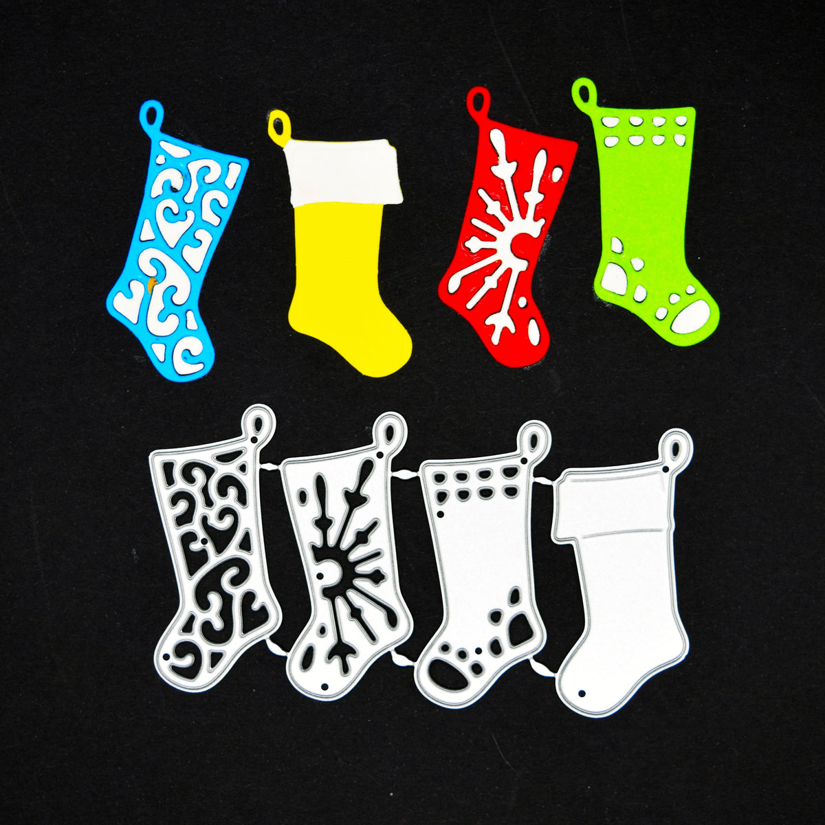 Four Christmas stocking metal cutting dies with blue, yellow, red and green paper examples on a black background.