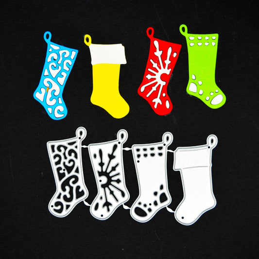 Four Christmas stocking metal cutting dies with blue, yellow, red and green paper examples on a black background.