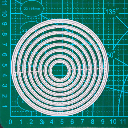 Stitched circle nesting metal cutting dies displayed on a centimetre cutting mat for clear size guidance.
