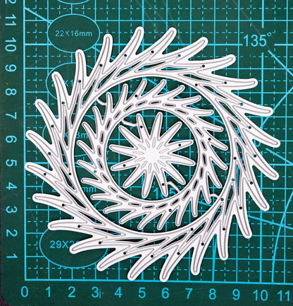 Decorative swirl circle dies on cutting mat for size reference