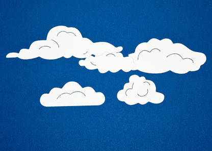 White cloud die cut shapes on blue background made using metal cutting dies