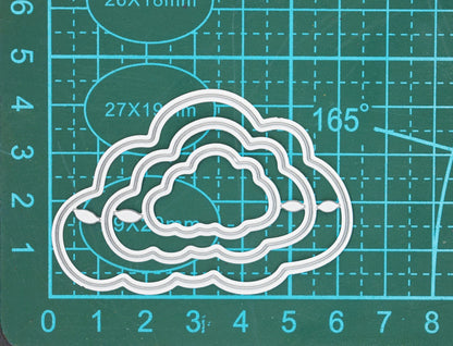 Cloud nesting dies photographed on cutting mat for sizing guidance