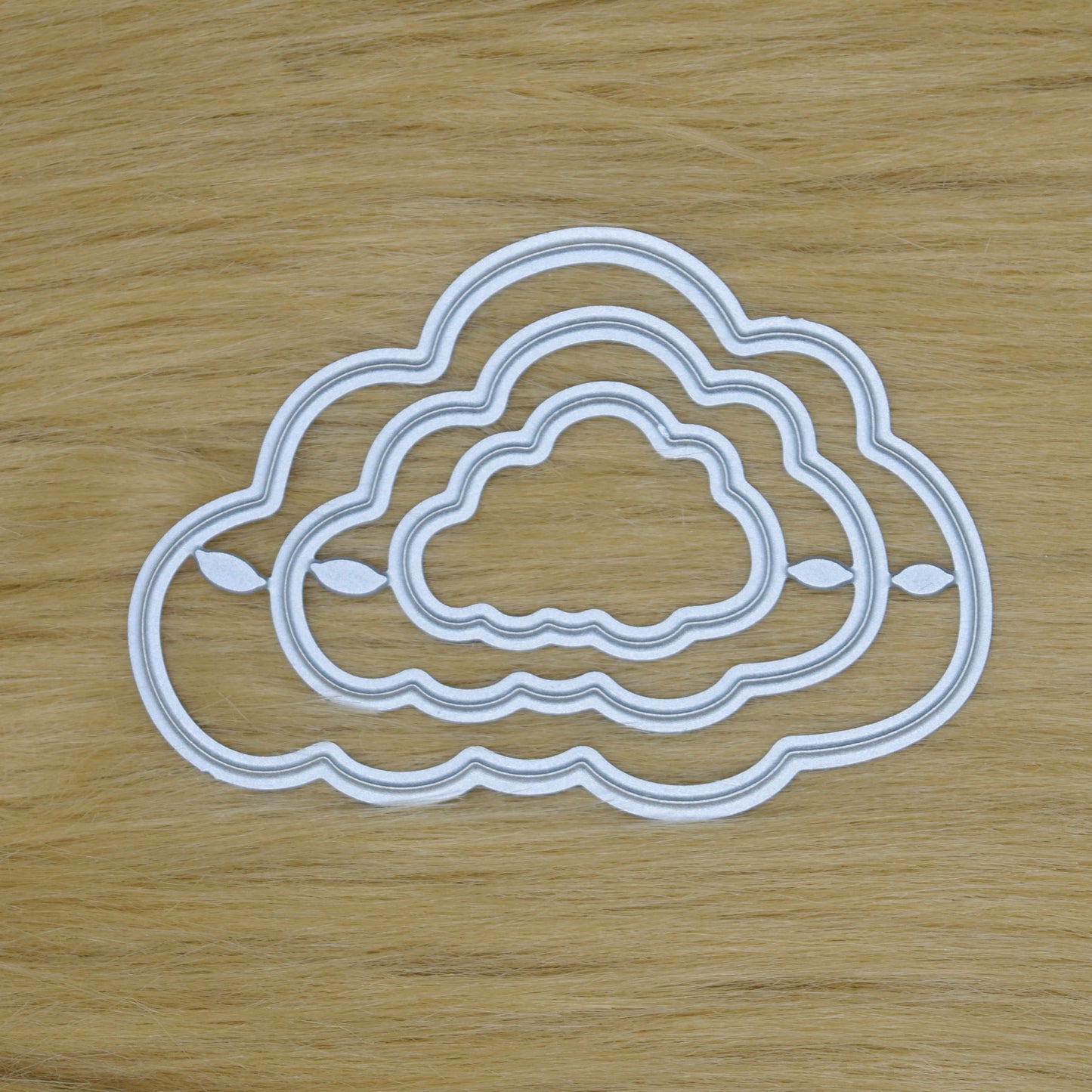 Cloud nesting frame dies photographed on faux fur background showing die details