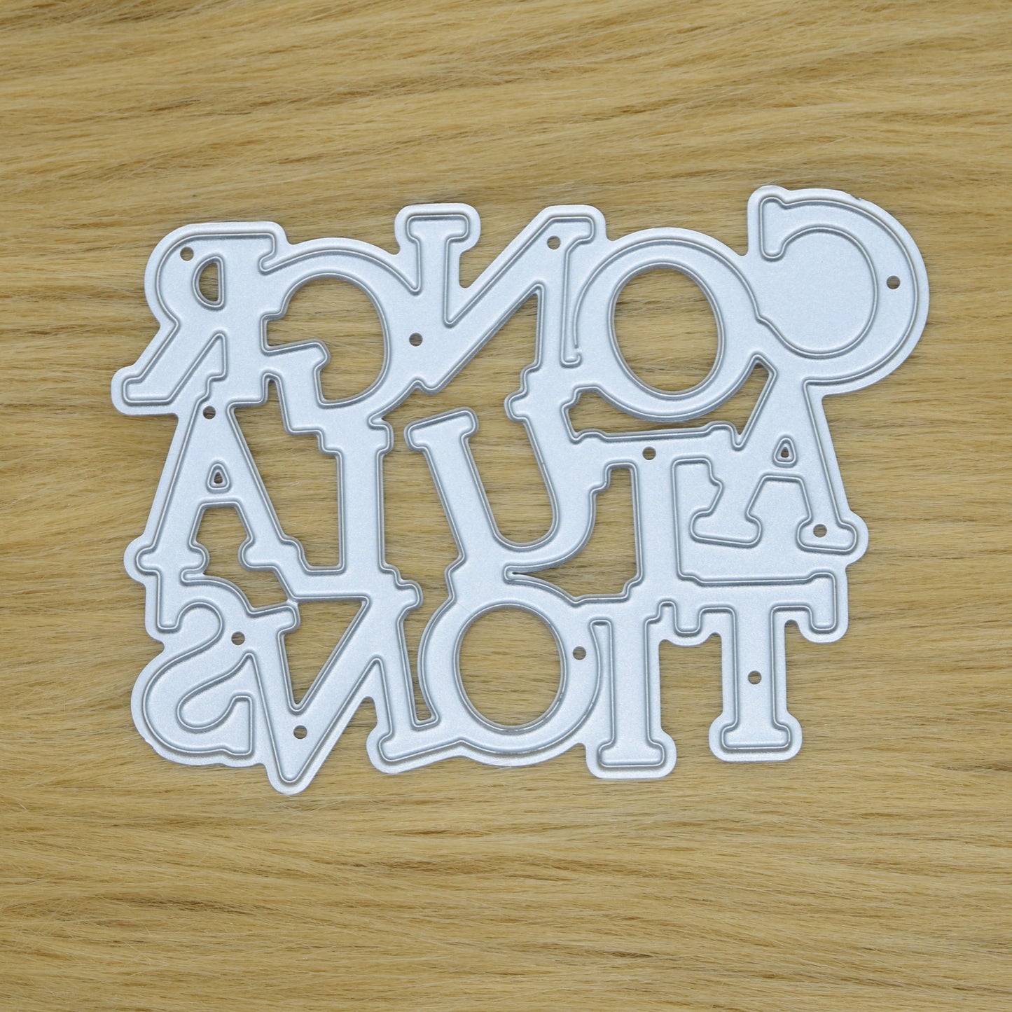 Congratulations sentiment metal cutting die on faux fur background