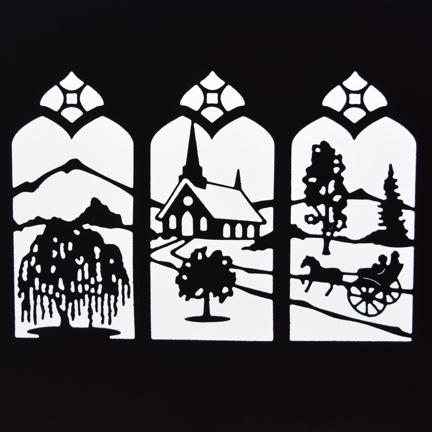Finished black countryside window scene die cut showing a church, trees, mountains, horse and cart within three decorative arched panels.
