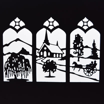 Finished black countryside window scene die cut showing a church, trees, mountains, horse and cart within three decorative arched panels.