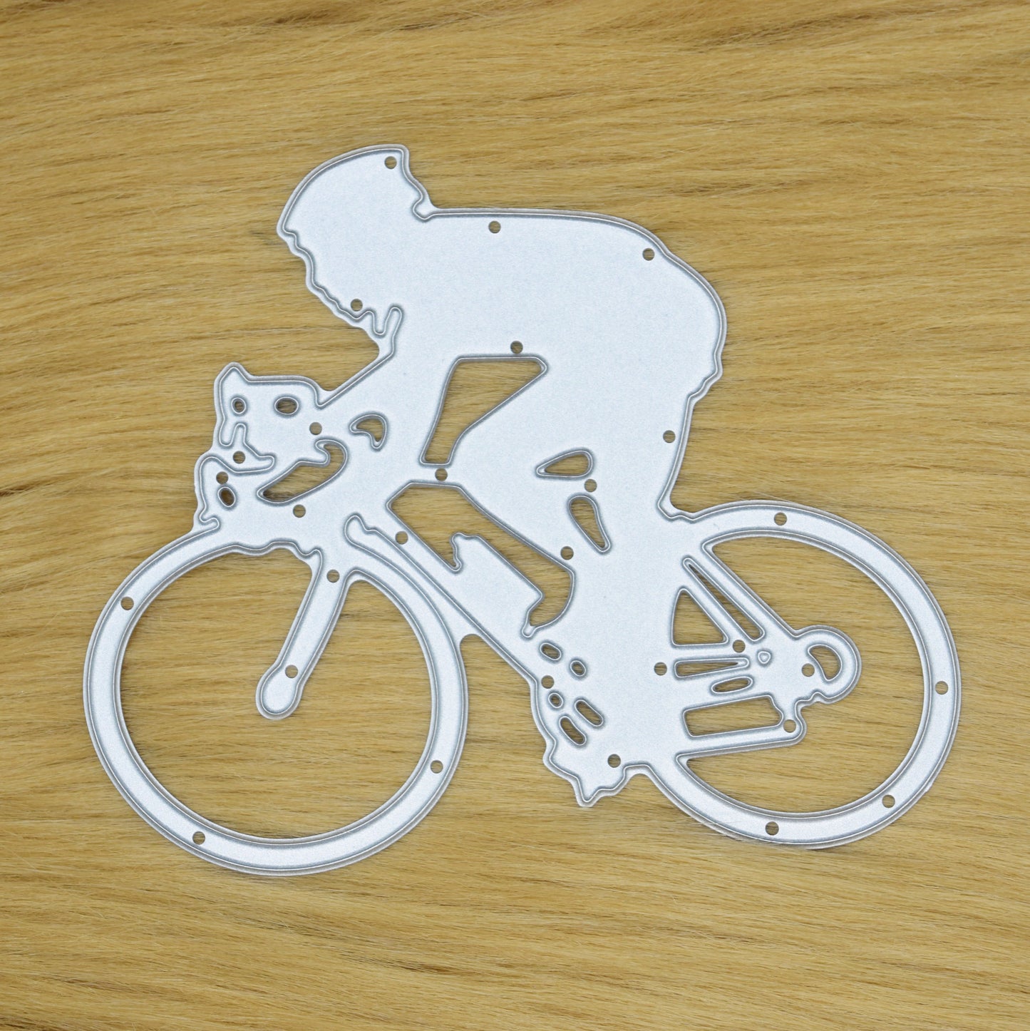 Cyclist metal cutting die on faux fur background showing man riding racing bicycle design