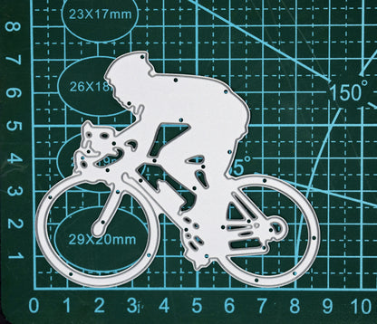 Cyclist metal cutting die on green cutting mat showing man riding racing bicycle design