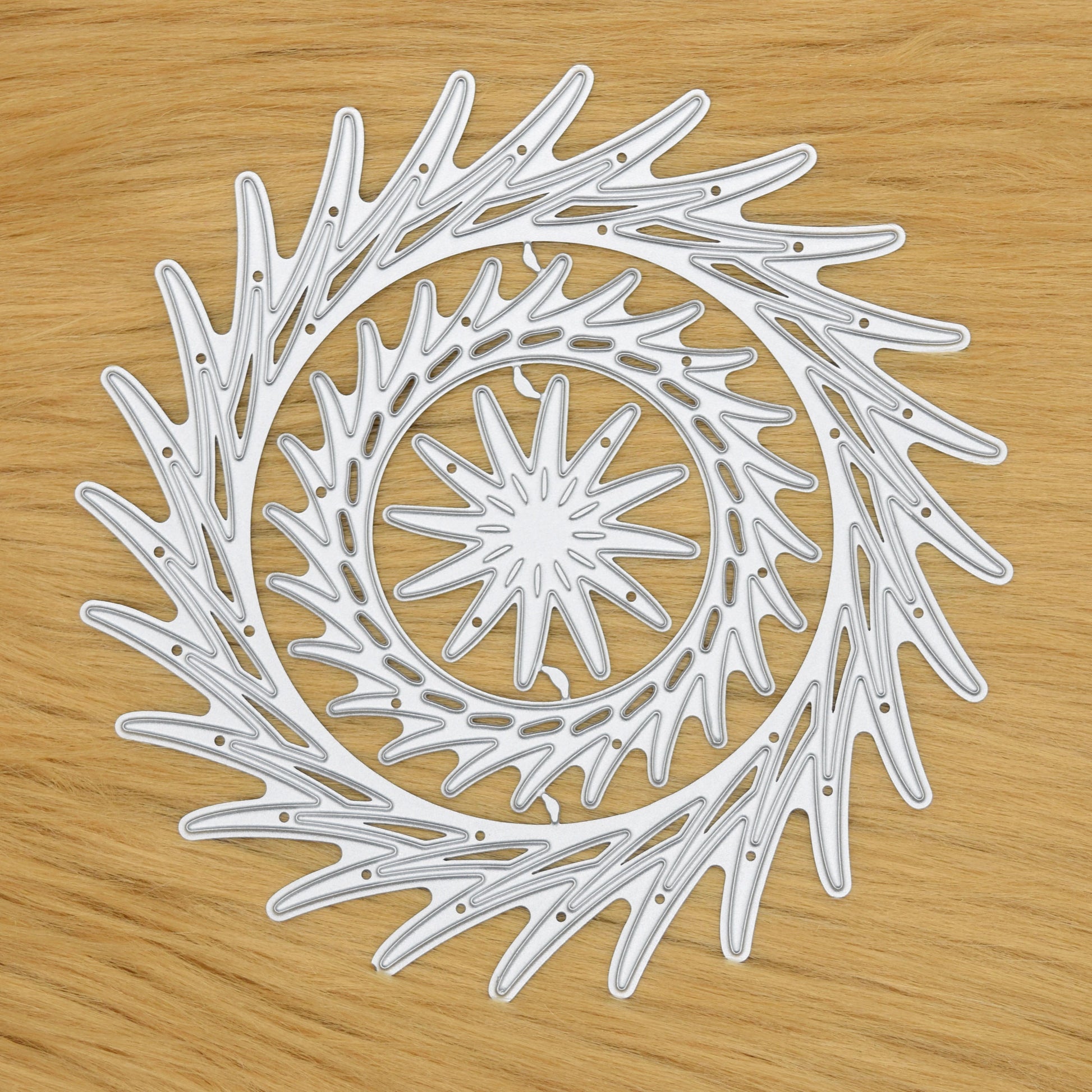 Layered circular swirl frame metal cutting dies on faux fur background