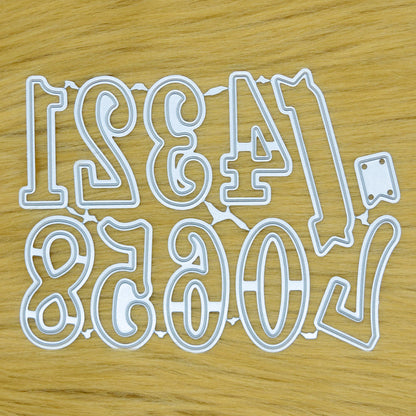 Decorative number metal cutting dies from zero to nine with a small banner die displayed on a tan faux fur background.