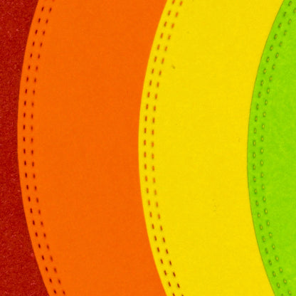 Close-up of colourful circle paper cuts showing the decorative double stitched edge produced by the nesting metal cutting dies.