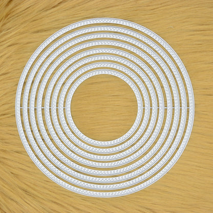 Set of eight large double stitch circle nesting metal cutting dies displayed on a tan faux fur background.