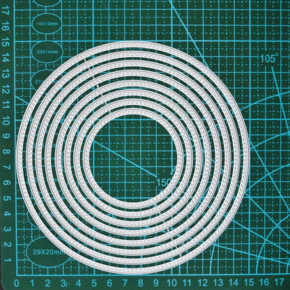 Set of eight large circle nesting metal cutting dies shown on a centimetre cutting mat for size reference.