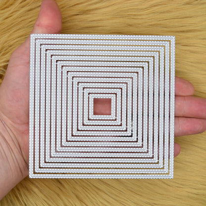 Twelve double stitched square nesting metal cutting dies held in a hand to demonstrate the overall size.