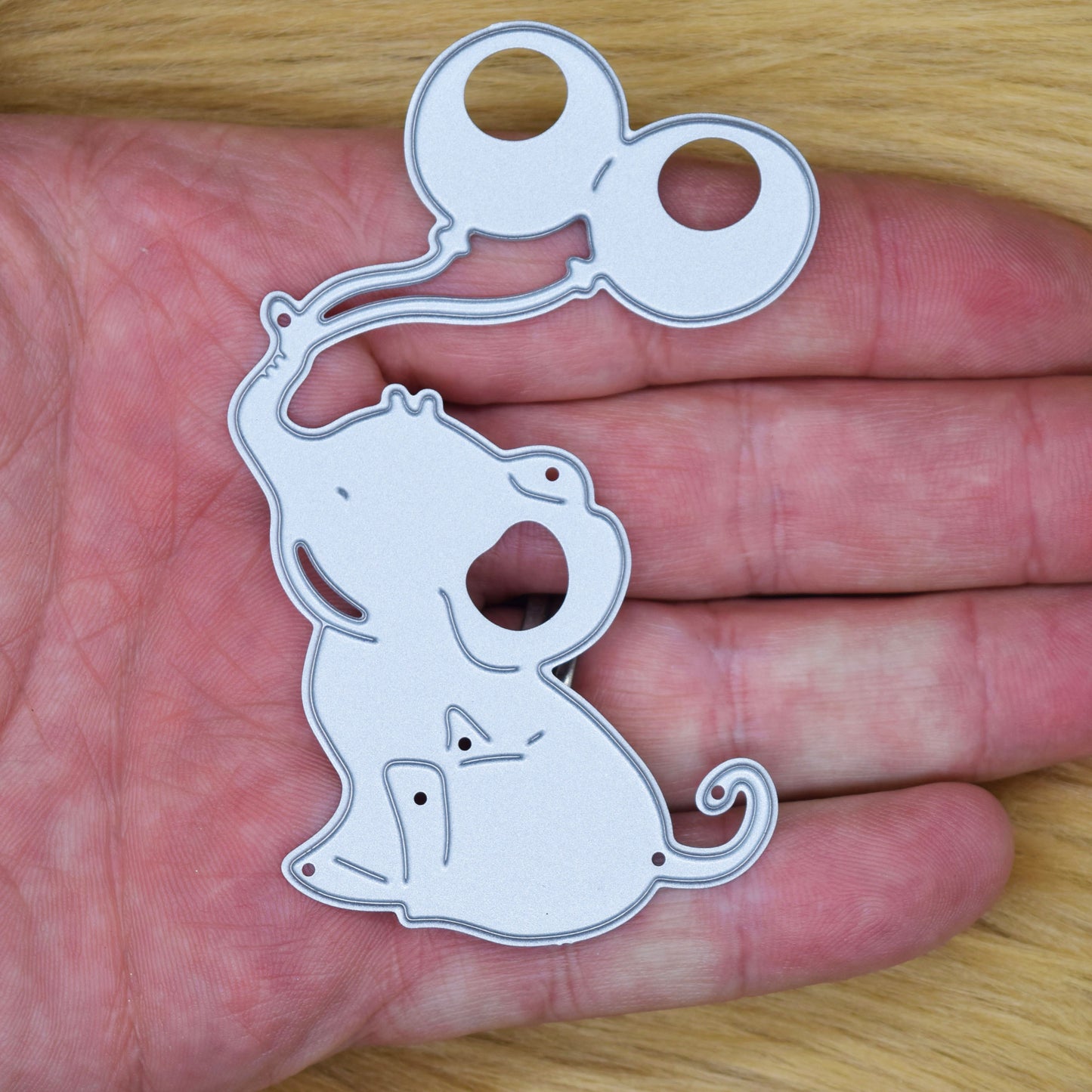 Baby elephant balloon metal cutting die shown in hand for size