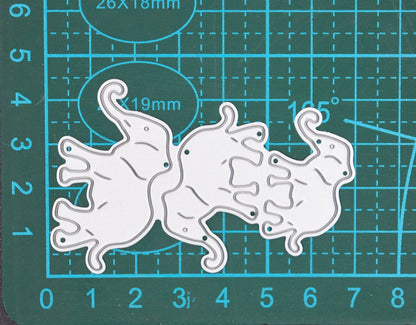 Three elephant metal cutting dies displayed on cutting mat showing approximate size for card making and scrapbook crafts
