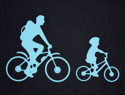 Blue family bicycle die cuts featuring adult and child cyclists for sports themed card making and paper craft projects