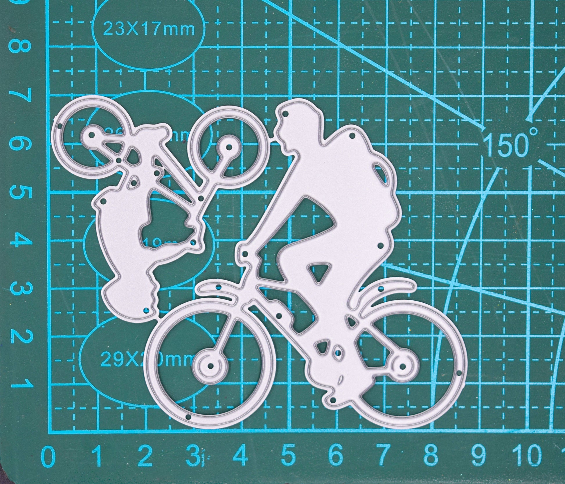 Man and child riding bicycles metal cutting die on cutting mat showing family cycling silhouette design for card making and papercrafts