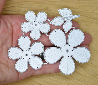 3D flower metal cutting dies held in hand showing size and embossed petal detail