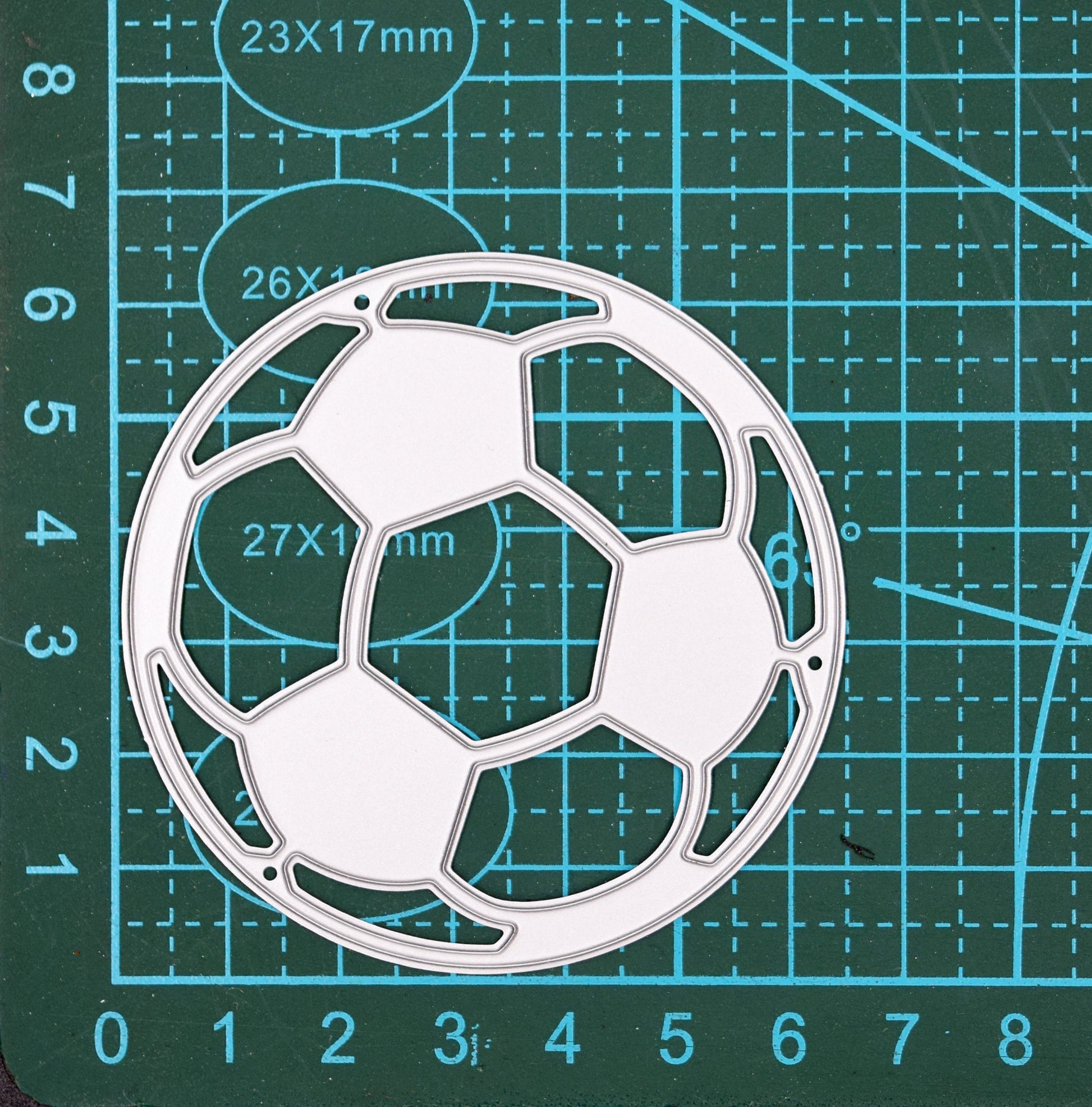 Football metal cutting die on measuring mat showing size