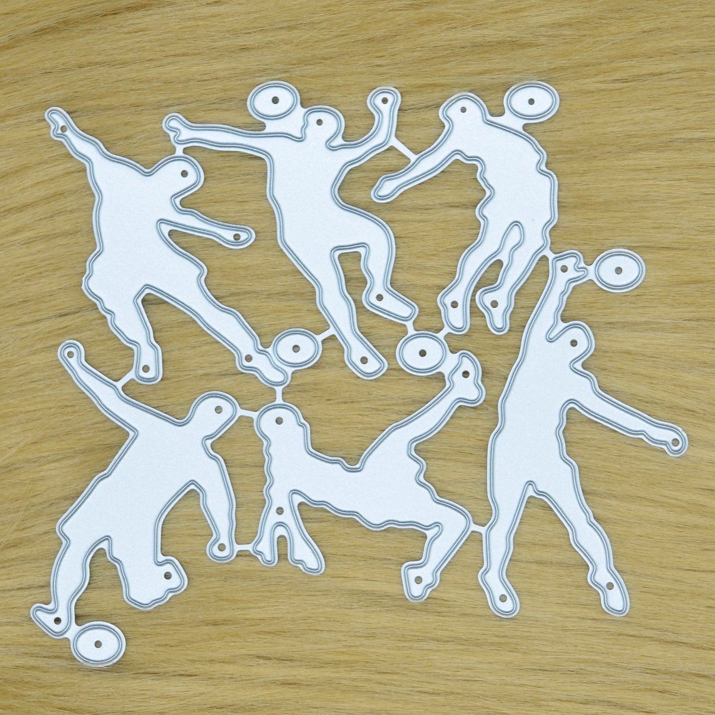 Football player metal cutting die set displayed on a faux fur background