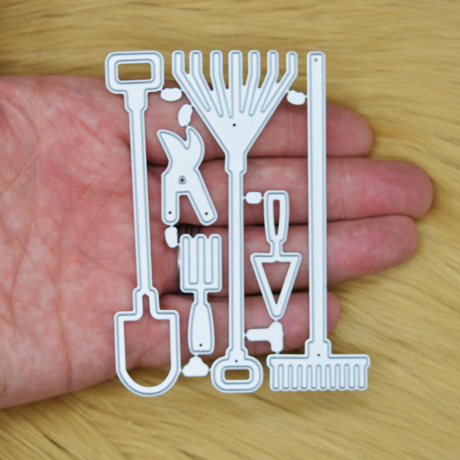 Garden hand tools metal cutting dies set shown in hand to demonstrate the die sizes