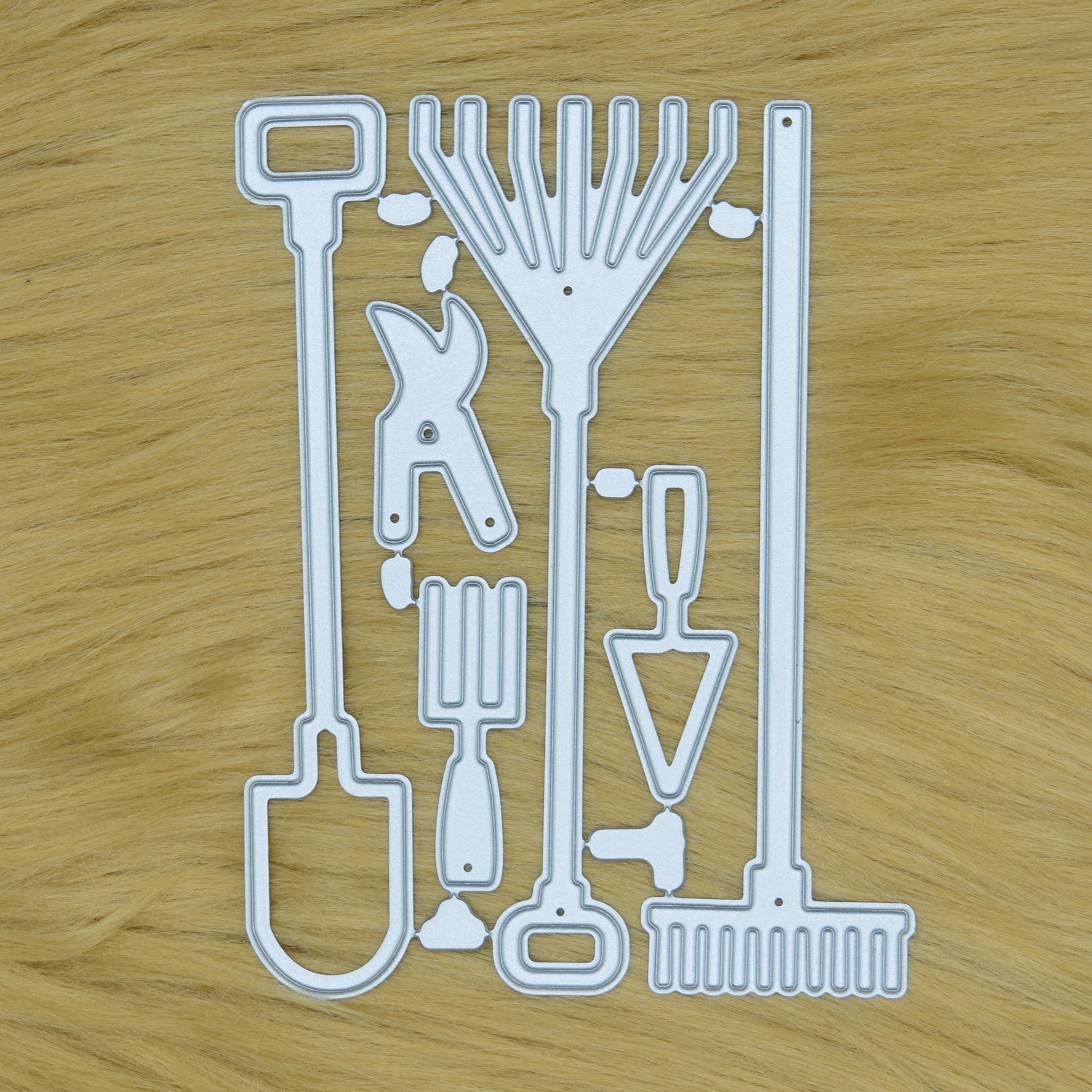 Garden hand tools metal cutting dies set displayed on a faux fur background for card making