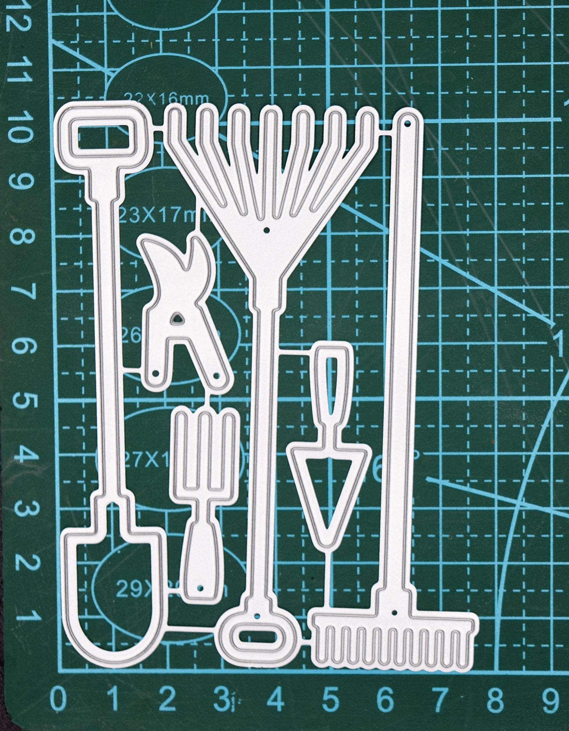 Garden hand tools metal cutting dies set shown on a cutting mat for size reference